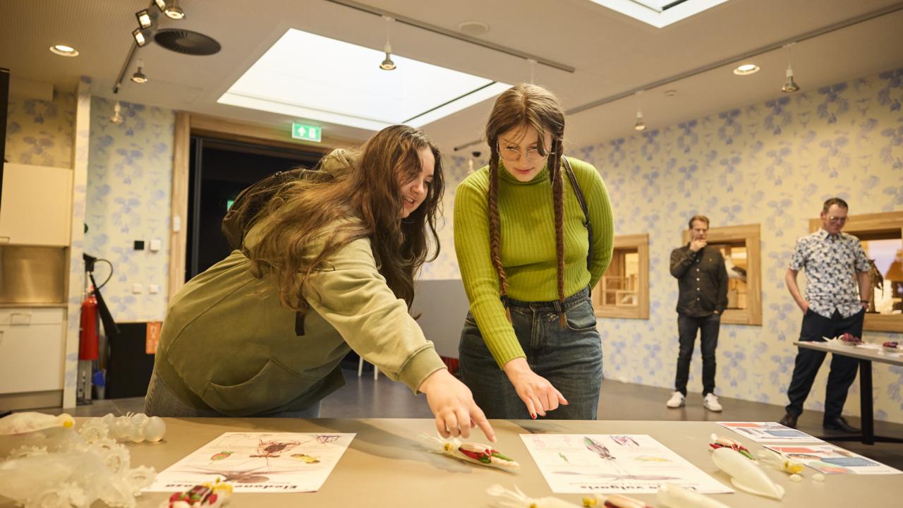 Twee docenten in opleiding bij een tafel met informatie
