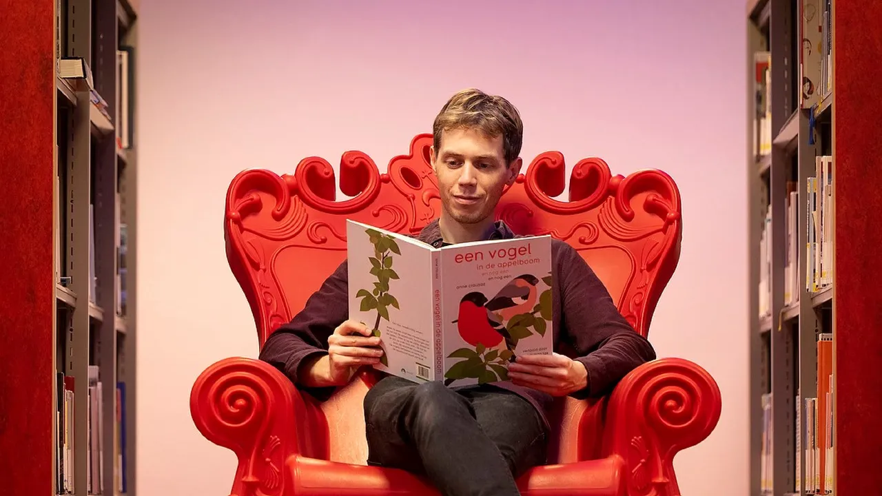Michiel Hooykaas in stoel met boek
