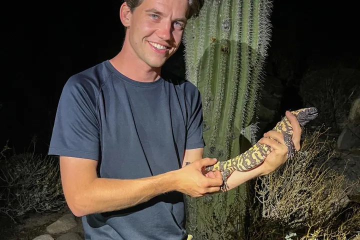 Mátyás houdt een gilamonster vast voor een cactus