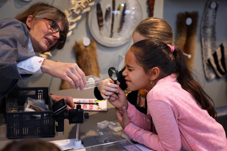 Een kind kijkt door een loep